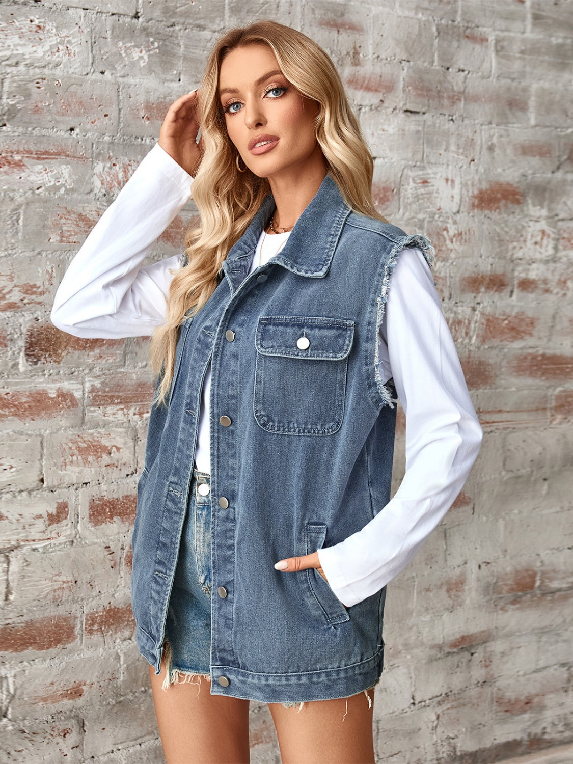Dusty blue denim utility vest with raw edges, button front, and chest pockets.