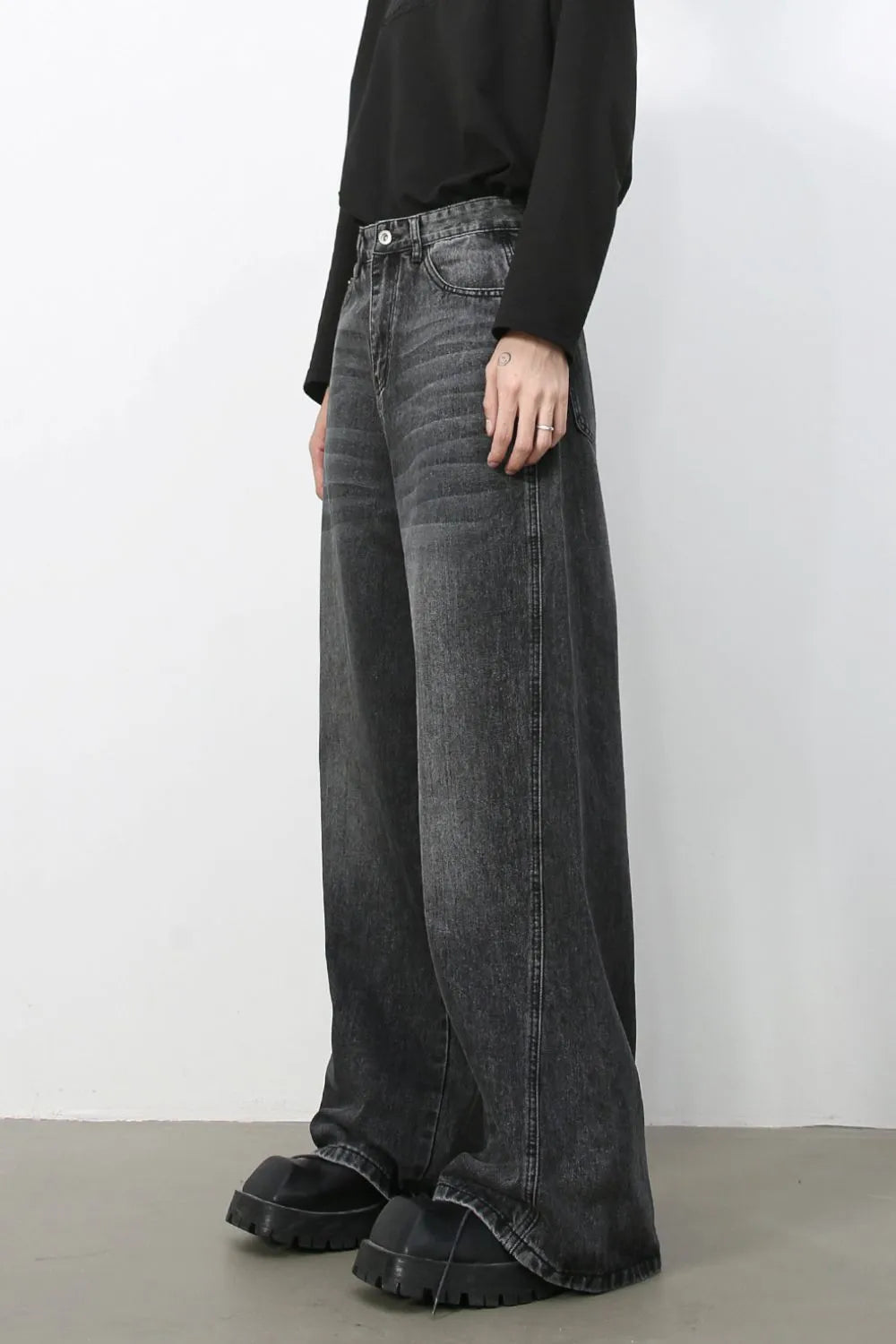 Dark wash denim trousers with exaggerated wide legs and a casual fit.