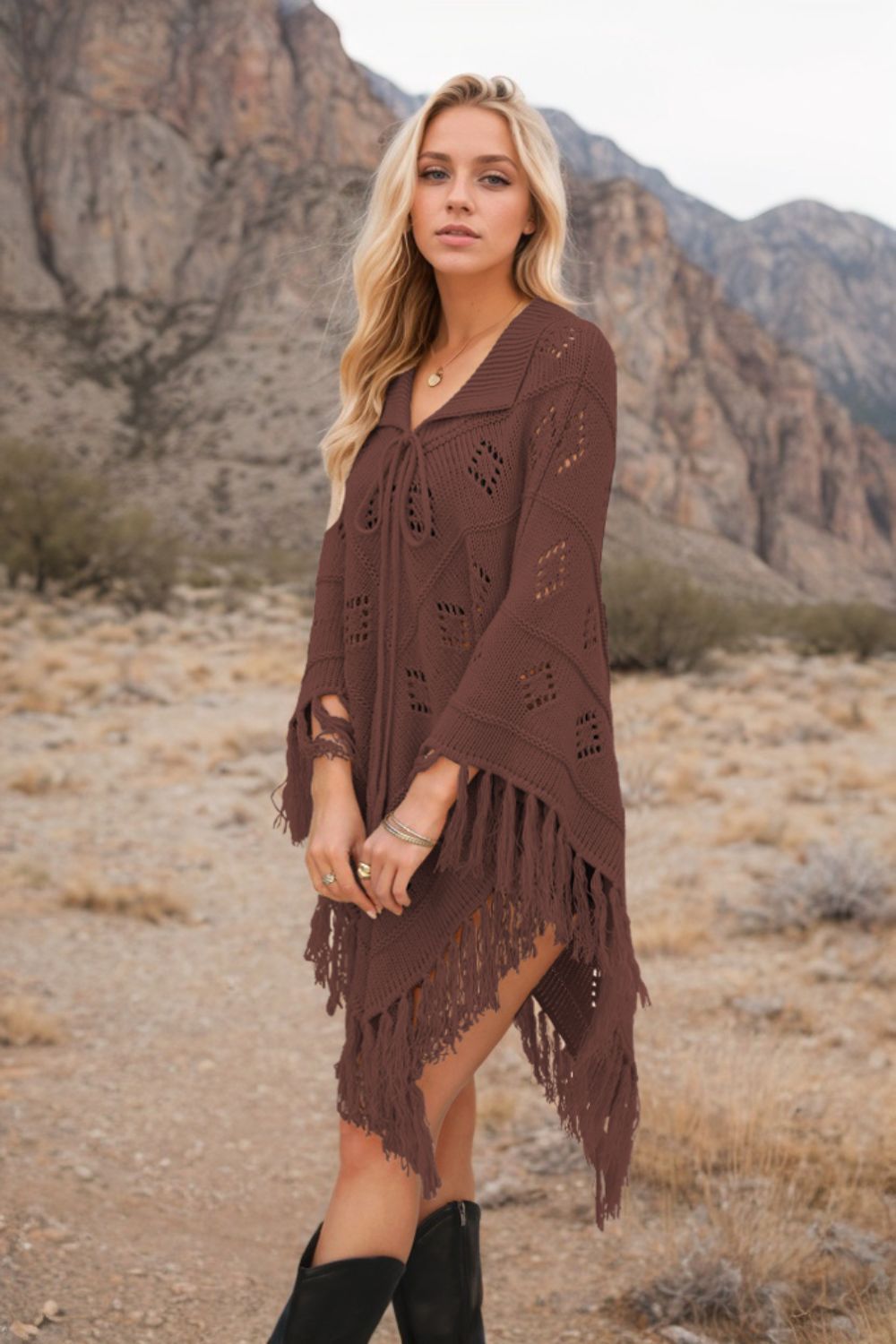 Brown knit poncho with geometric pattern, tie neck, and fringe details.