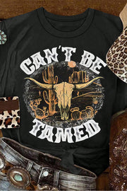Black cotton blend graphic tee with bull skull and cactus desert scene, "Can't Be Tamed" text.