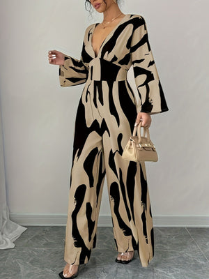 Abstract print wide leg jumpsuit with V-neck and belted waist.