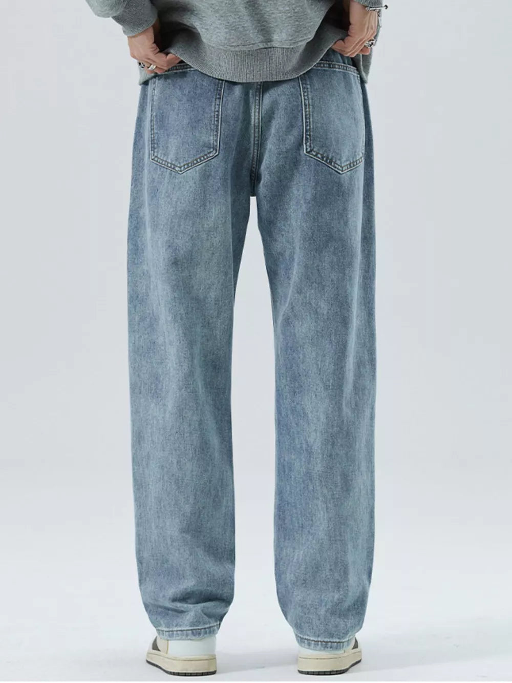 Light blue 100% cotton men's loose-fit jeans with drawstring waist and back pockets.