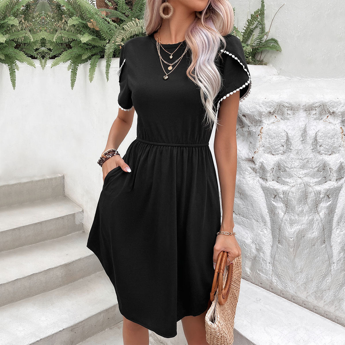 Black day dress with scalloped sleeves and pockets, cinched waist, and casual midi length.