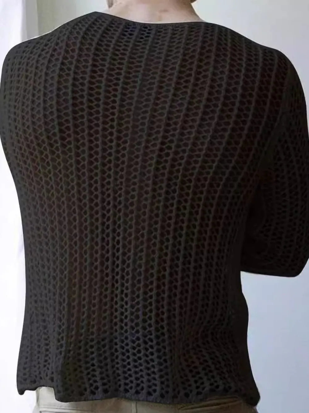 Black open-knit crewneck long sleeve sweater with a textured pattern.