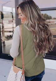 Quilted sherpa-lined utility vest in sage green with diamond stitching, worn by a woman.