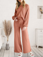 Wide-leg knit loungewear set in coral with drawstring waist and long sleeves.