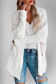 White popcorn knit open cardigan with textured details and long sleeves.