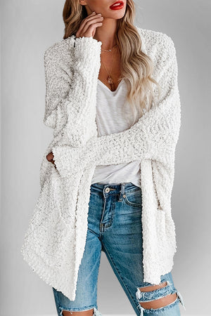 White popcorn knit open cardigan with textured details and long sleeves.