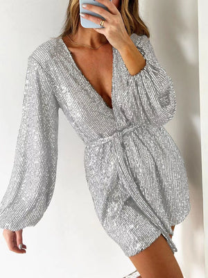 Silver sequin wrap romper with blouson sleeves and deep V-neck.