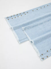 Light wash denim wide-leg jeans with studded side slits and frayed hem.