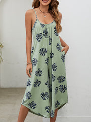 Sage green culotte jumpsuit with monstera print, gathered bust, and pockets.