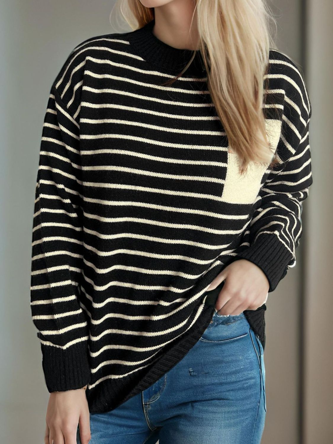 Asymmetrical stripe knit sweater in black and tan with a single chest pocket detail.
