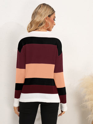 Colorblock crewneck sweater in acrylic with horizontal stripes of burgundy, peach, black, and white.