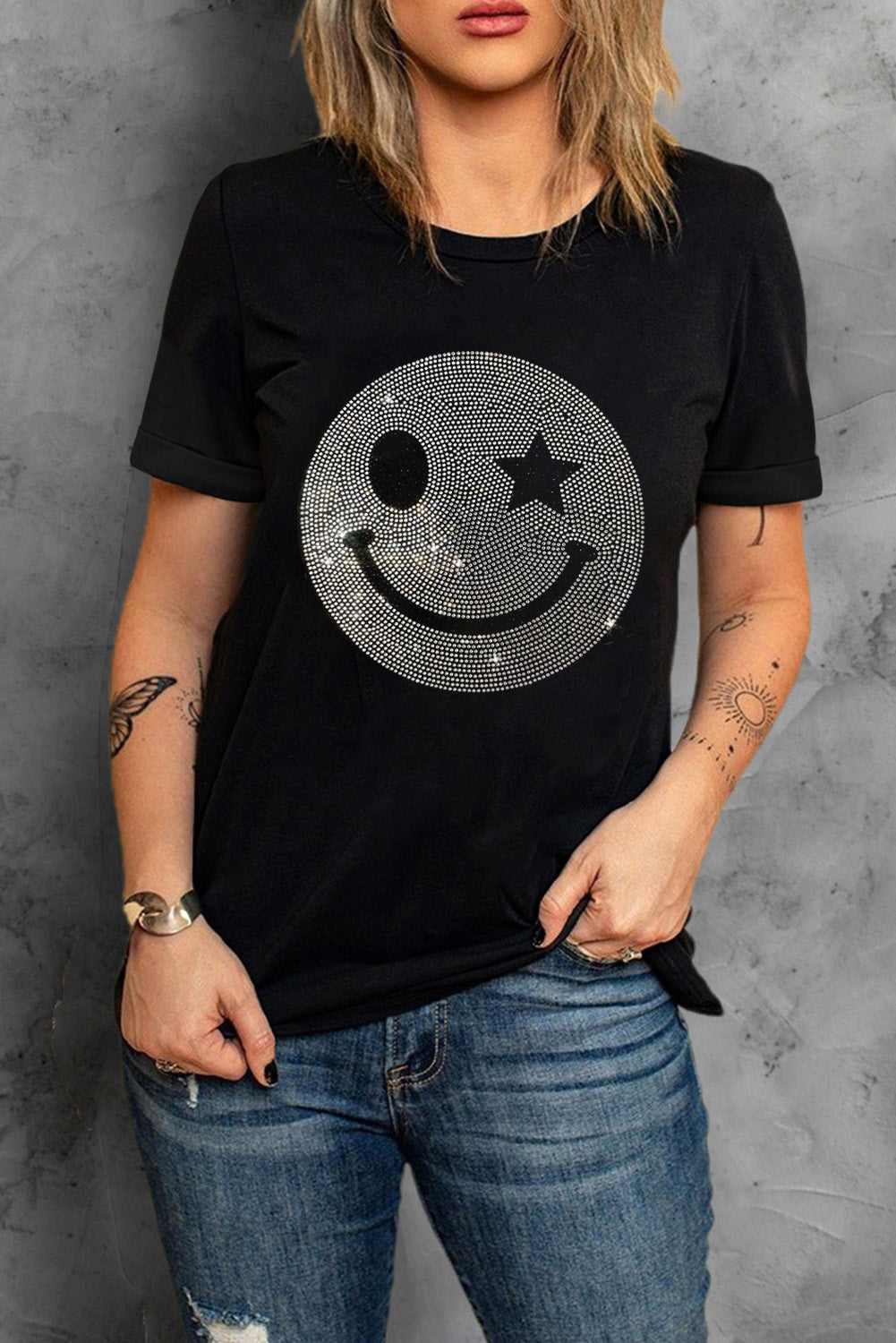 Black t-shirt with rhinestone smiley face graphic and rolled sleeves.