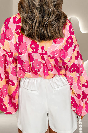 Floral print blouse in strawberry pink with balloon sleeves and a button front, styled with white shorts.
