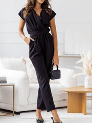 Black draped wrap-front jumpsuit with short sleeves and a tie waist.