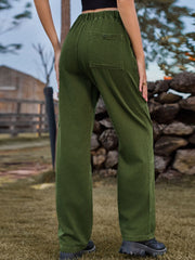 Dark green cargo denim trousers with elastic waist and buttoned back pocket.