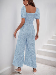 Light blue floral smocked bodice jumpsuit with puff sleeves and wide legs.