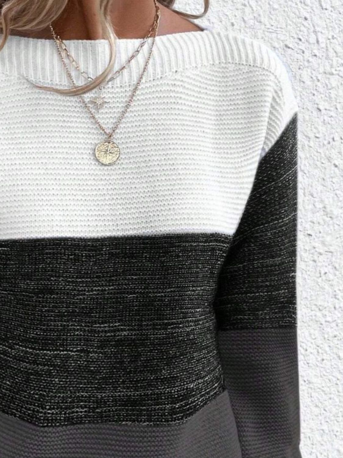 Colorblock boatneck ribbed knit sweater in white, black, and gray.
