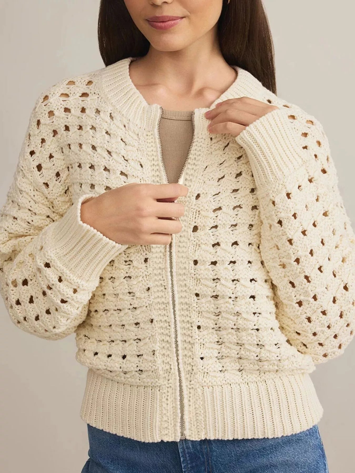Beige openwork zip-up cardigan with crew neck and ribbed cuffs and hem.