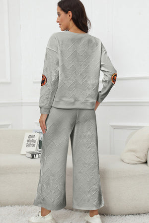 Textured grey loungewear set with geometric pattern and pumpkin patch detail on sleeves.
