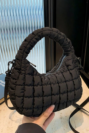 Black padded crescent crossbody bag with sculptural texture and top handle