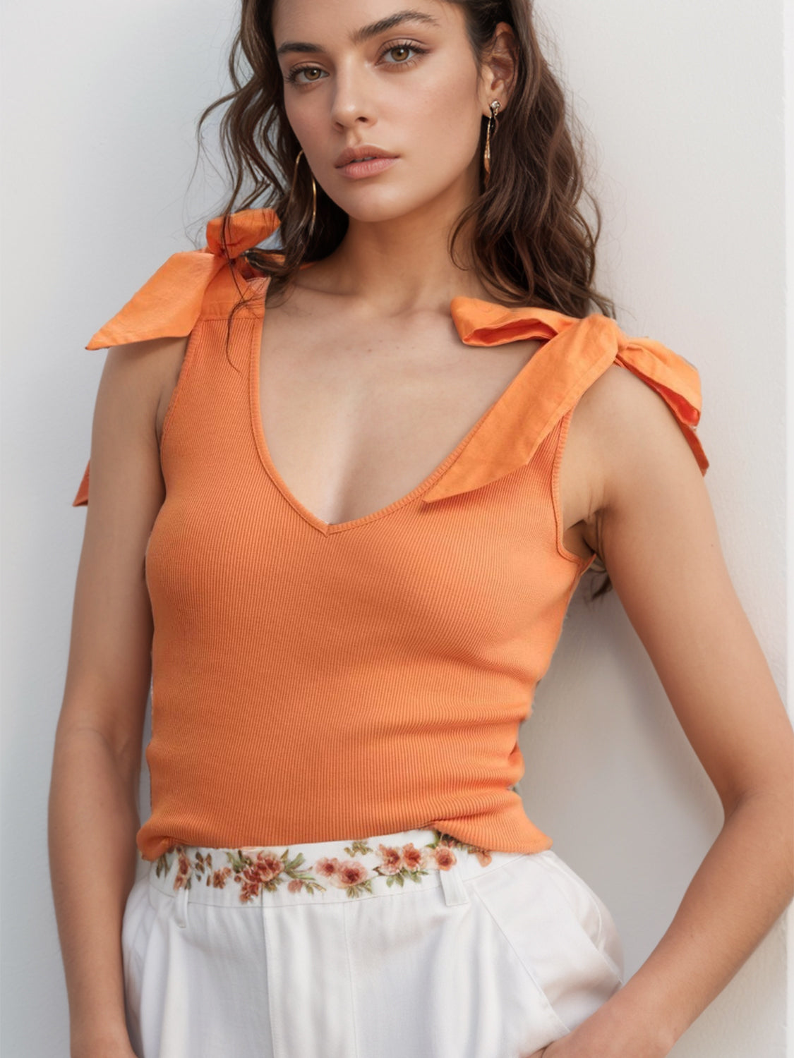 Orange ribbed knit tank top with bow shoulder detail and V-neck