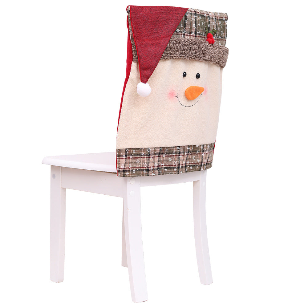 Festive snowman chair cover with Santa hat and plaid trim for Christmas dining decor.