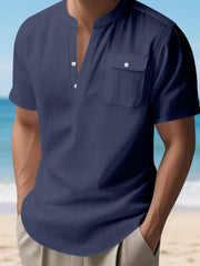 Navy blue short sleeve henley shirt with band collar and chest pocket.