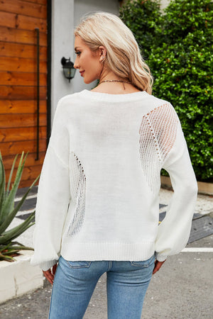 White knit sweater with slit detail on back and sleeves, crew neck, long sleeves.