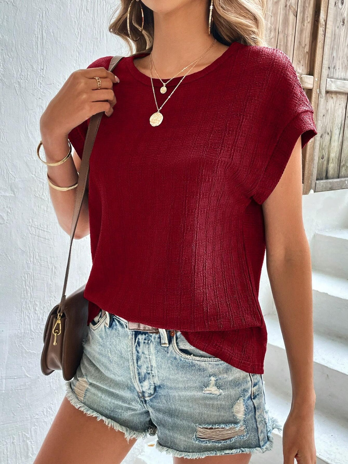 Burgundy woven texture cap-sleeve blouse with a relaxed fit