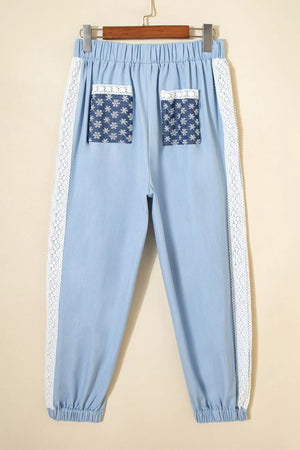 Light blue maternity pants with wide legs, lace trim, and floral print pockets.