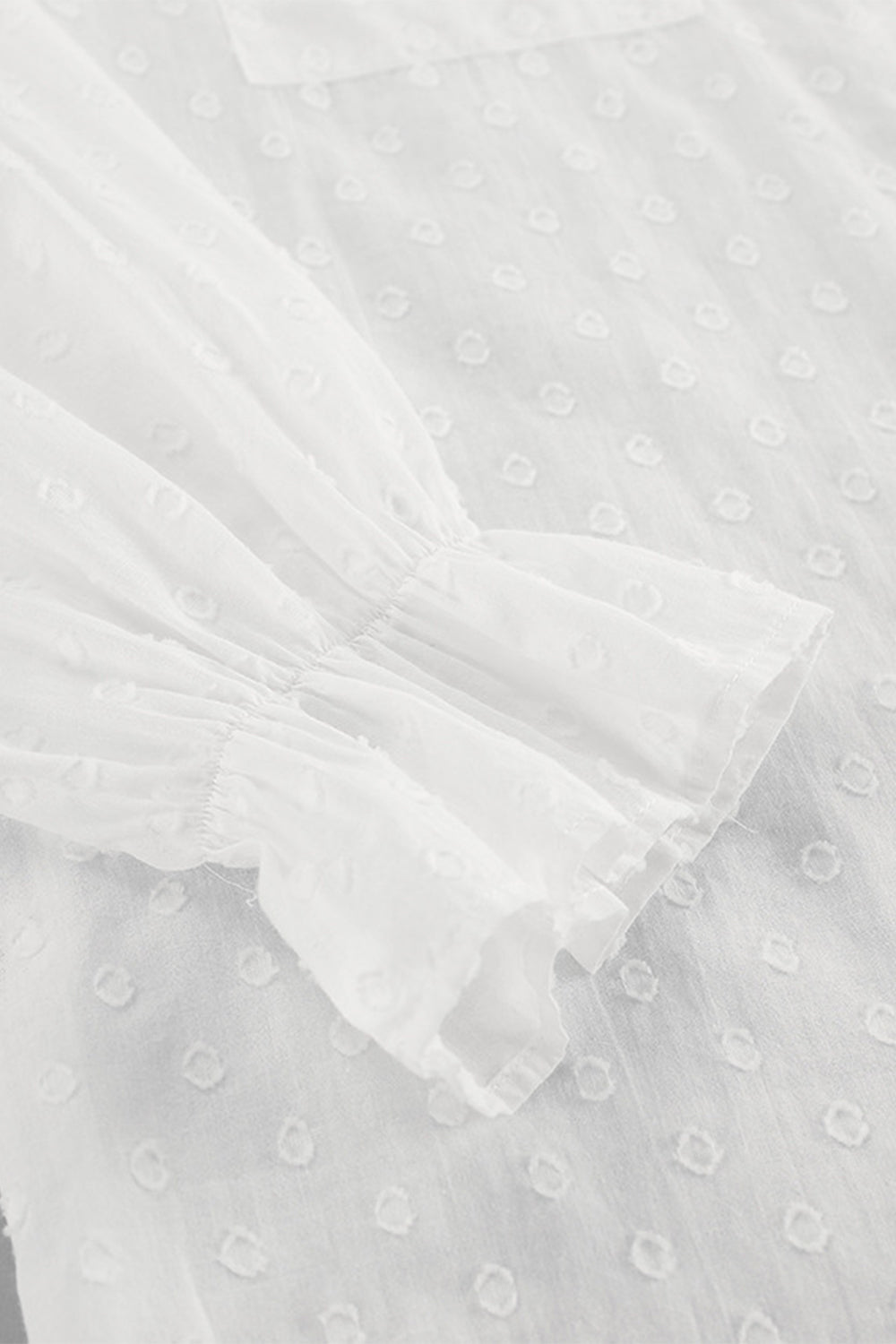 White textured ruffle trim shirt with gathered sleeves and a dotted pattern.