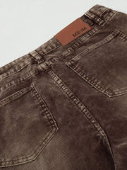 Brown corduroy joggers for men, showing back pockets and leather logo patch.