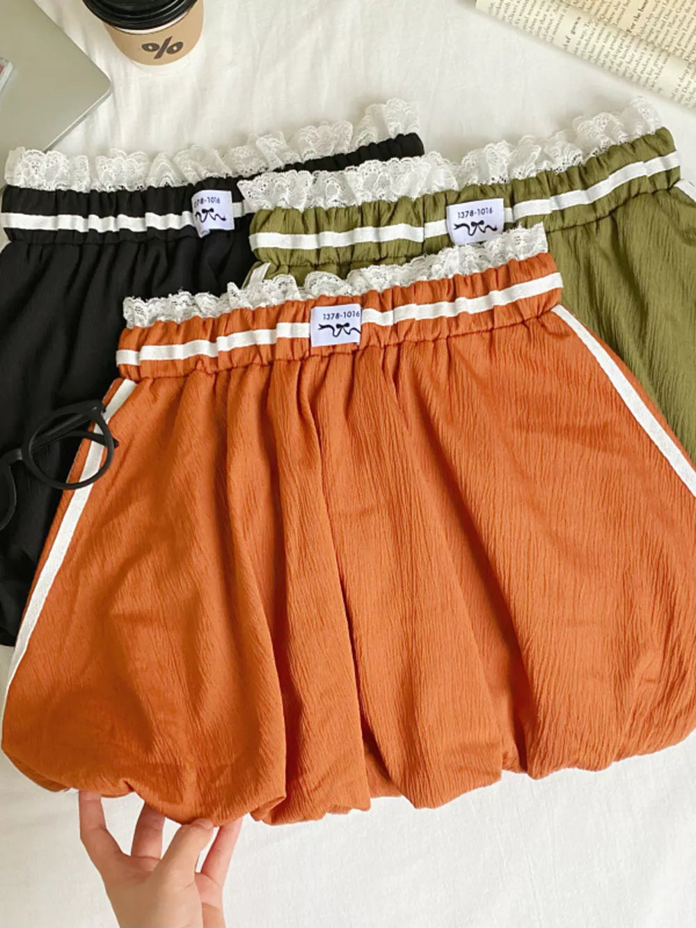 Lace-trimmed gathered waist mini skirt in orange with white side stripes, black and army green options.