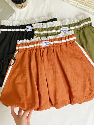Lace-trimmed gathered waist mini skirt in orange with white side stripes, black and army green options.