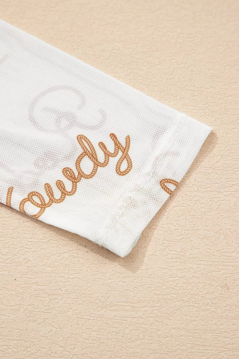 White sheer mesh shirt with brown rope-style text detail