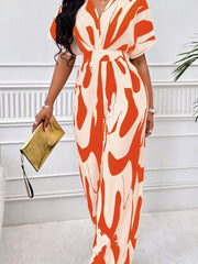 Orange and cream abstract print wide-leg romper with short sleeves and V-neck.