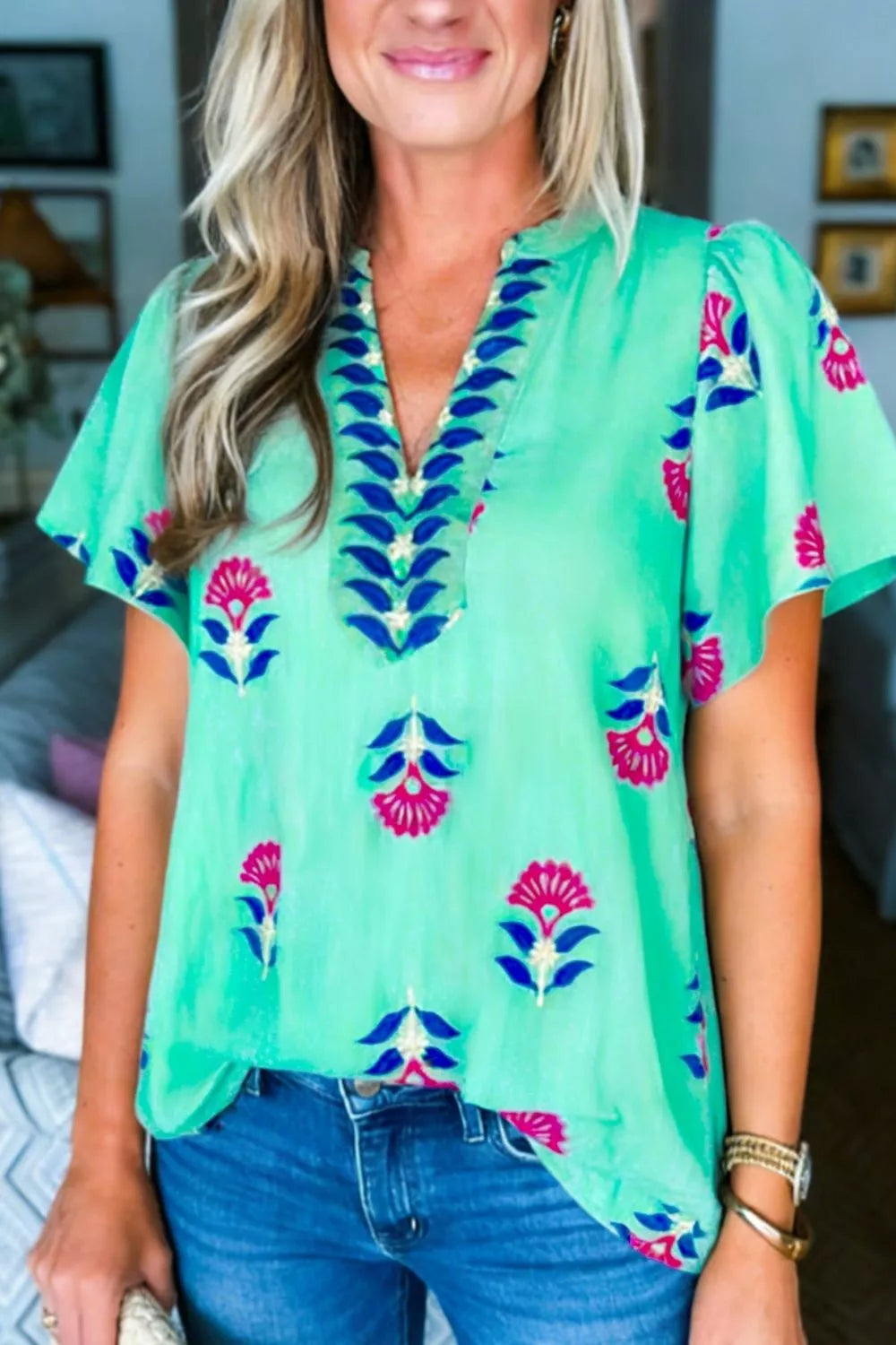 Embroidered floral v-neck flutter sleeve blouse in light blue with pink and blue floral embroidery.