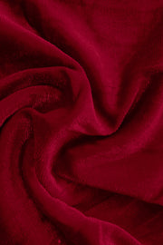 Plush velvet wide-leg trousers in burgundy, showing fabric texture and drape.