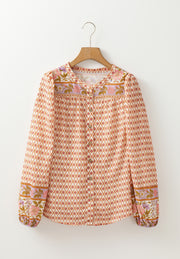 Bohemian print blouson sleeve top with button front and floral cuffs.