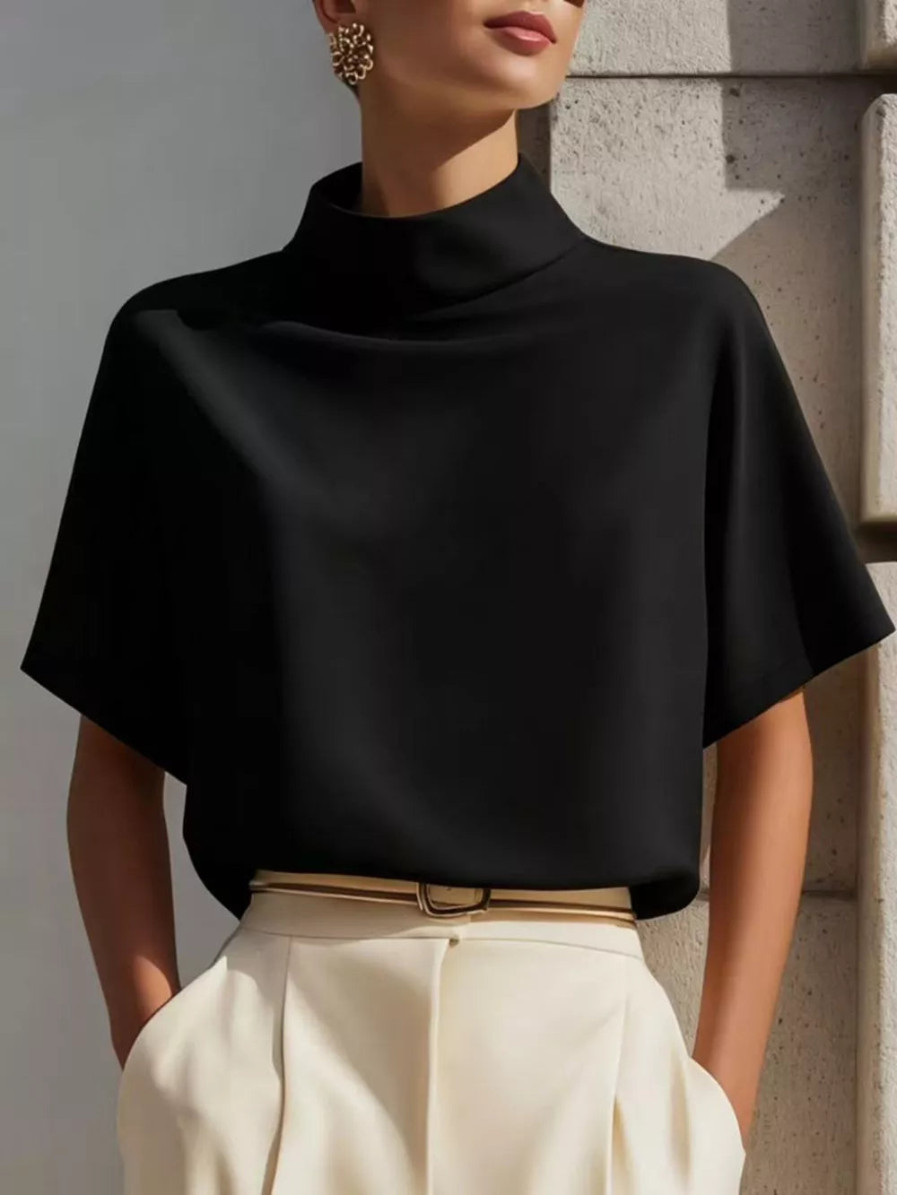 Black mock neck t-shirt with relaxed sleeves in polyester, styled with cream pants.