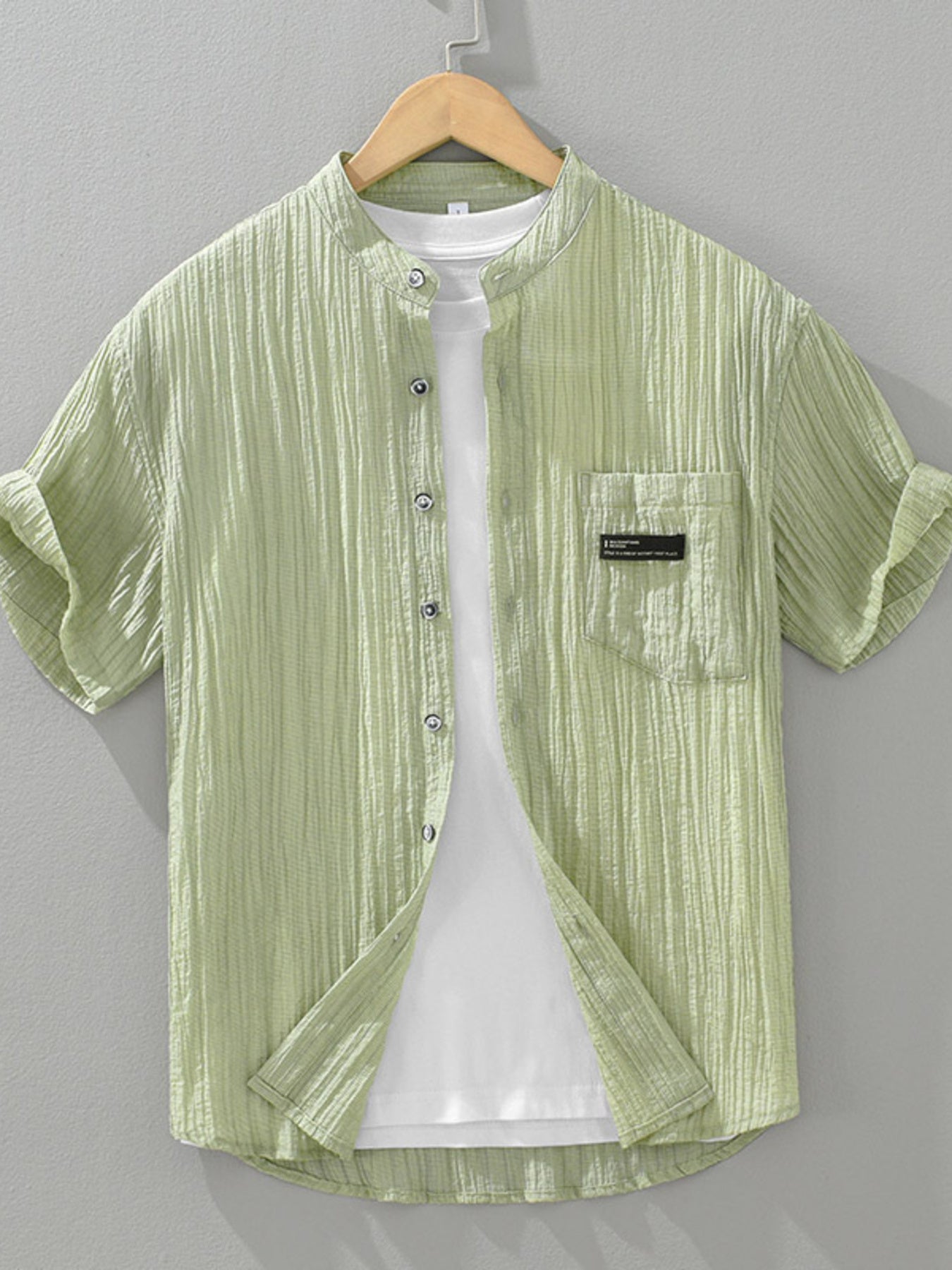 Light green textured button-up shirt with mandarin collar and chest pocket, short sleeves.