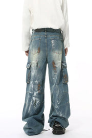 Artisan denim cargo pants in medium wash with paint splatters and wide legs.