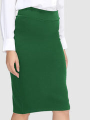 Green pencil skirt with a high waist, styled with a white button-down shirt.