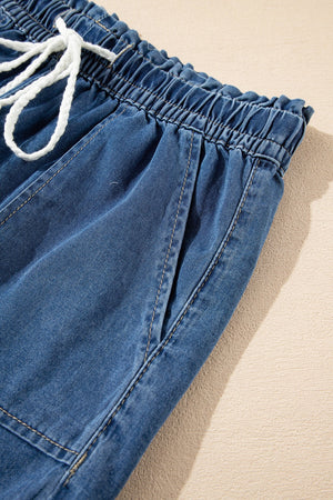 Navy denim drawstring shorts with elastic waist and white tie.