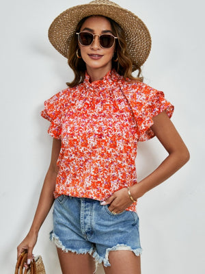 Orange floral blouse with ruffled neckline and flutter sleeves