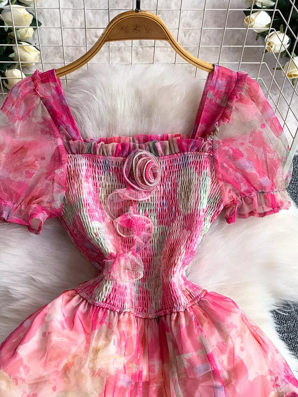 Floral tiered midi dress in pink with smocked bodice and puff sleeves.
