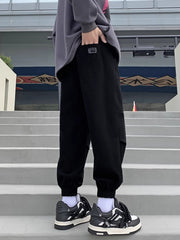 Black relaxed fit joggers with pockets and elastic cuffs.