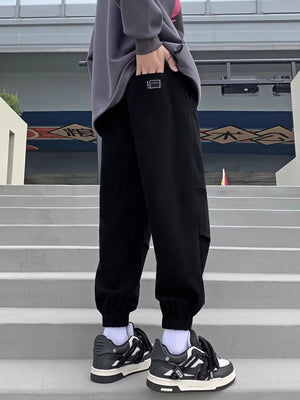Black relaxed fit joggers with pockets and elastic cuffs.